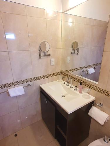 een badkamer met een wastafel en een spiegel bij JM Departamento Hermoso 4 in Ushuaia