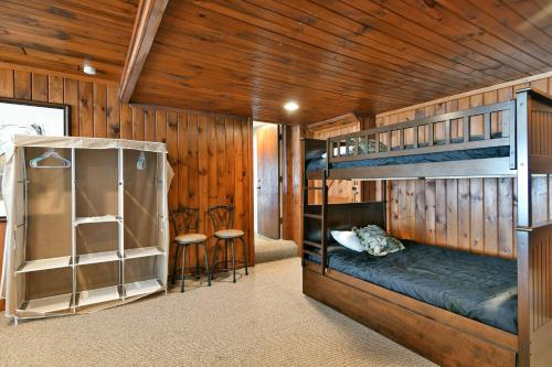 two bunk beds in a room with wooden walls at Spruce Haven home in Hayward