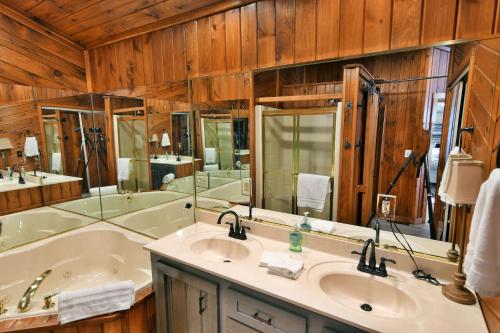 a bathroom with a tub and two sinks and a tub at Spruce Haven home in Hayward