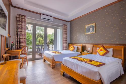 a hotel room with two beds and a balcony at Sun Viet Resort Phu Quoc in Phu Quoc