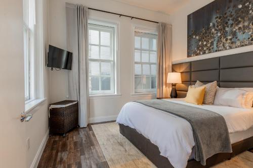 1 dormitorio con 1 cama y TV de pantalla plana en Inner Harbor's Best Furnished Luxury Apartments apts en Baltimore