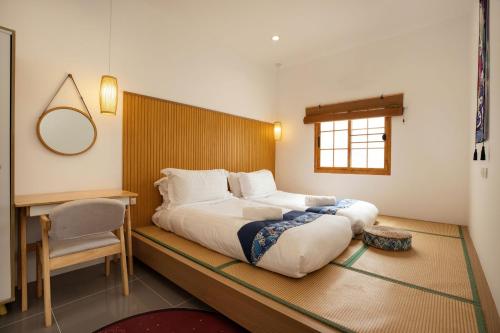 1 dormitorio con 1 cama grande y escritorio en Villa Sunrise Garden B190, en Ban Muang Mai