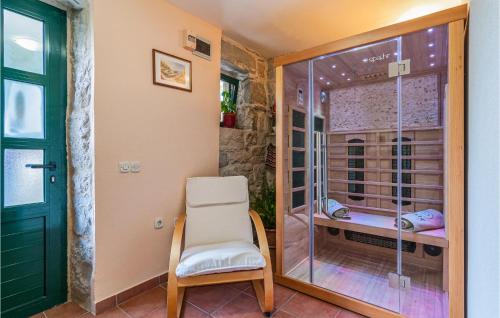 a room with a shower with a chair and a glass door at Stunning Home In Ostrvica With Sauna, Wifi And Outdoor Swimming Pool in Ostrvica