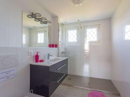 ein weißes Badezimmer mit Waschbecken und Spiegel in der Unterkunft Charmant appartement à 15min de St Jean avec jardin - FR-1-4-493 in Urrugne