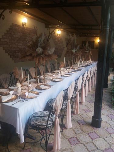 a long long table with white tables and chairs at Хотел Милениум in Yambol