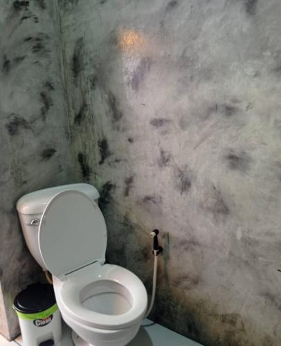 a bathroom with a white toilet in a room at Baan Mae Khian Cafe & Boutique Hotel in Phra Nakhon Si Ayutthaya