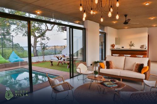 een woonkamer met een bank en een zwembad bij Misty Villa Powered by TSC in Pussellawa