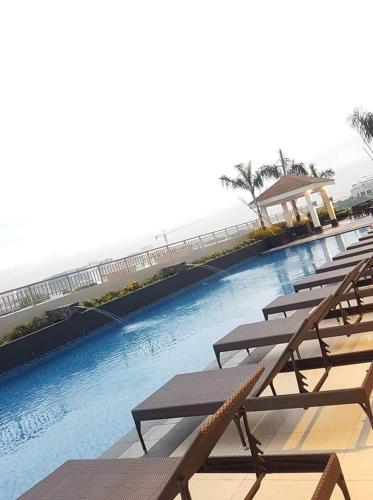 a row of picnic tables next to a swimming pool at Jk Coastal Inn in Manila