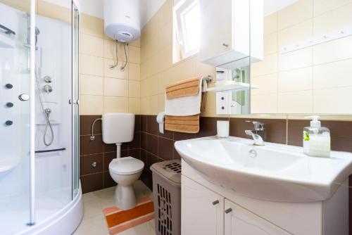 a bathroom with a sink and a toilet and a shower at Babara beautiful setting right on beach with modern facilities in Metajna