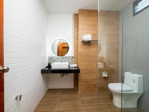 ein Bad mit einem WC und einem Spiegel in der Unterkunft Moonlight Cafe and Hotel in Tha Sala