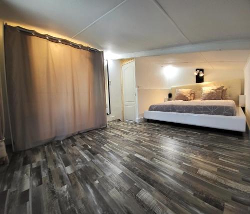 1 dormitorio con 1 cama y suelo de madera en Tiny House Chaleureuse au Style Contemporain Minimaliste en Le Tampon