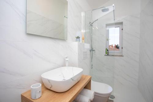 a white bathroom with a sink and a toilet at La casa di Marko in Rabac