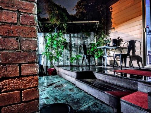 a patio with a table and chairs and a brick wall at Richmond Private Rooms - 151 Hoddle Homestay in Melbourne