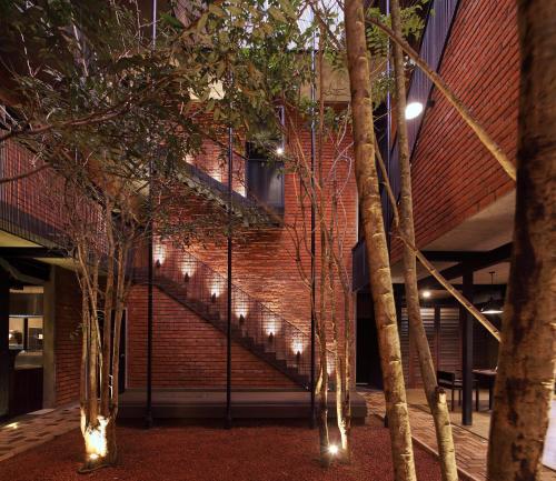 een gebouw met een trap en wat bomen en verlichting bij BBQ HUB Ella in Ella