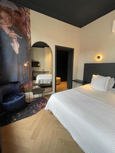 a bedroom with a bed and a large painting on the wall at Hotel Montanus in Bruges