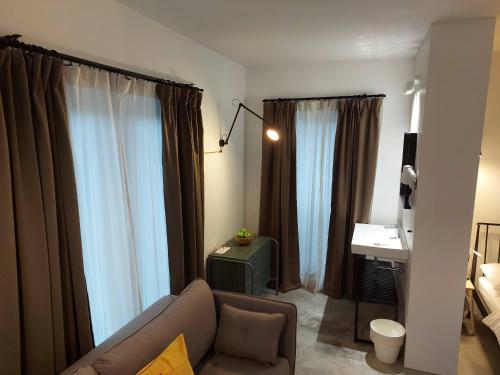 sala de estar con cortinas, sofá y escritorio en Bed & Breakfast Mozaik, en Liubliana