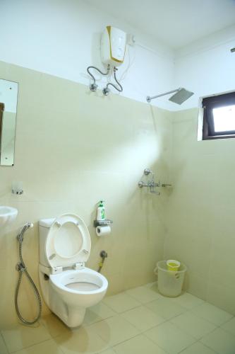 a bathroom with a toilet and a camera on the wall at Da Inn Home Stay in Garacherāma