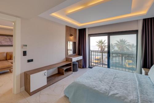 a bedroom with a large bed and a balcony at Ege Birlik Seasight Suites in Kuşadası