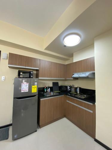 a kitchen with wooden cabinets and a refrigerator at Le 10 The Radiance Manila Bay in Manila