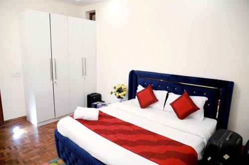 um quarto com uma cama grande e almofadas vermelhas em Fortune Home Service Apartment 2Bhk ,E28 Saket 1A em Nova Deli