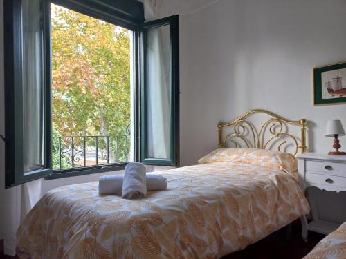 a bedroom with a bed with a large window at Rest . . . Heliópolis in Seville