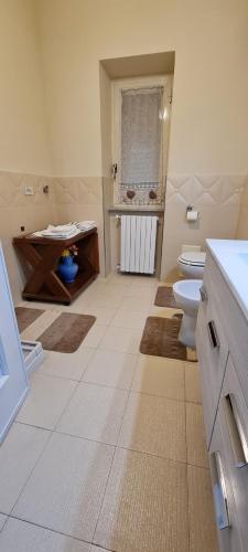 a bathroom with a toilet and a sink and a window at Casa Arianna in Avella