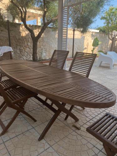 Une table et des chaises en bois sont disponibles sur la terrasse. dans l'établissement VILLA ANGELA splendida villa a stone's throw from the sea, à San Pietro in Bevagna