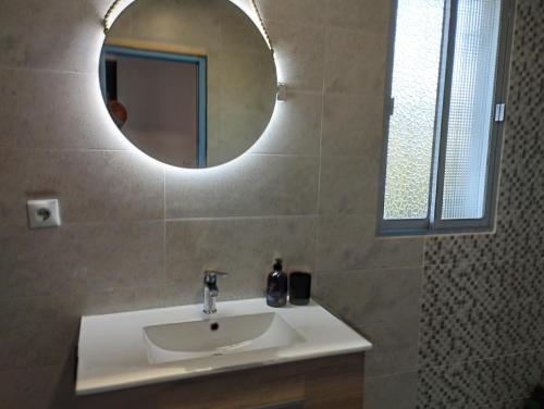 y baño con lavabo blanco y espejo. en CASA RURAL HUERTA DEL MEDIO, en Granada
