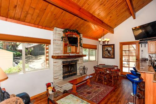 uma sala de estar com uma lareira de pedra e uma mesa em 1931 - Mountain Adventure home em Big Bear Lake