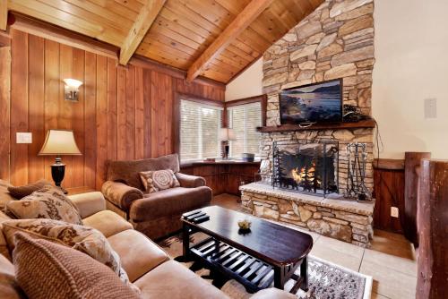 ein Wohnzimmer mit einem Sofa und einem Kamin in der Unterkunft 2020 -Bear Tracks home in Big Bear Lake