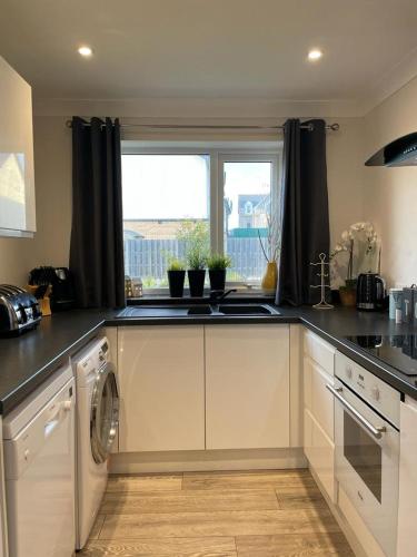 a kitchen with a sink and a dishwasher at Holiday home, Tywyn, great location in Tywyn