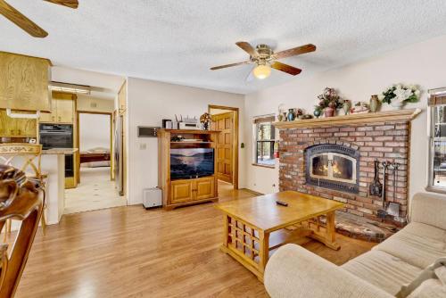 sala de estar con chimenea de ladrillo y mesa en Three-Bedroom House, en Big Bear Lake