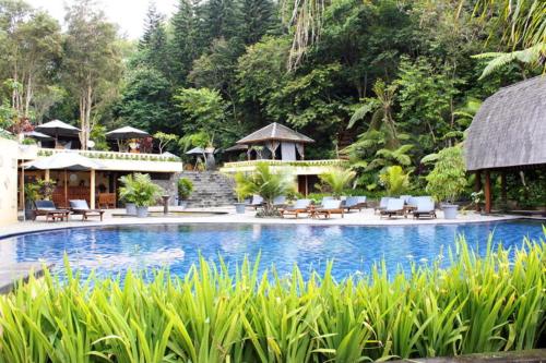 a resort with a swimming pool with chairs and tables at SanGria Resort And Spa in Lembang