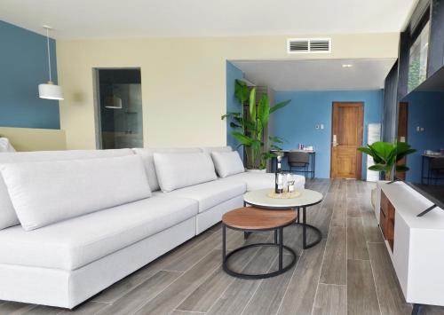 uma sala de estar com um sofá branco e uma mesa em H Hotel El Nido - Vegan Friendly Hotel em El Nido