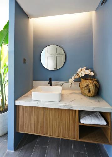 a bathroom with a sink and a mirror at H Hotel El Nido - Vegan Friendly Hotel Managed by H Hospitality Group in El Nido