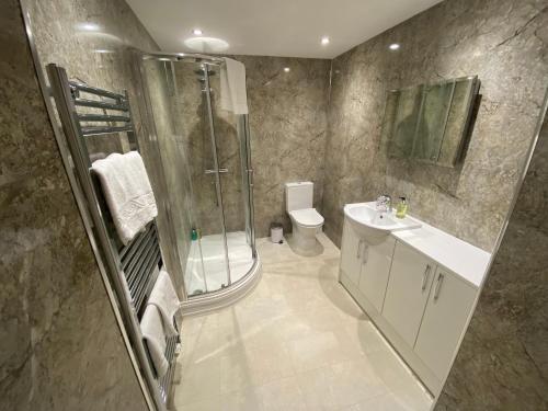 uma casa de banho com um chuveiro, um lavatório e um WC. em The Fairhaven Hotel em Weymouth