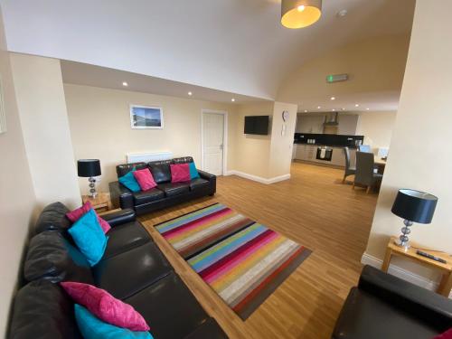 The Fairhaven Hotel في ويماوث: غرفة معيشة مع أريكة جلدية سوداء ووسائد ملونة