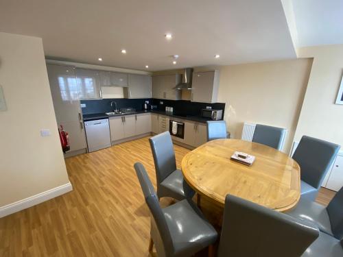 a kitchen with a wooden table and chairs in a room at The Fairhaven Hotel in Weymouth