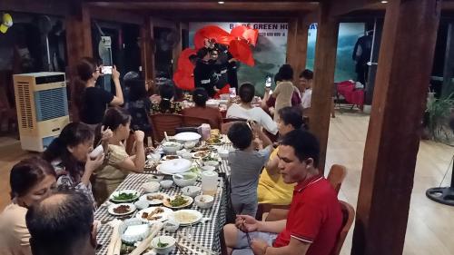 Ba Be Green Homestay في Bak Kan: مجموعة من الناس يجلسون على طاولة يأكلون الطعام