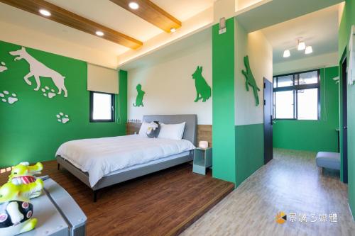 a bedroom with green walls with a bed and dog decals at 快樂狗寵物民宿--證號2598 in Hualien City