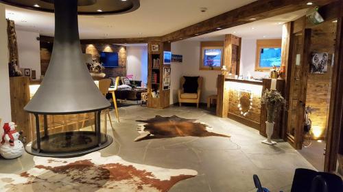 a living room with a fireplace in the middle at Panorama Ski Lodge in Zermatt