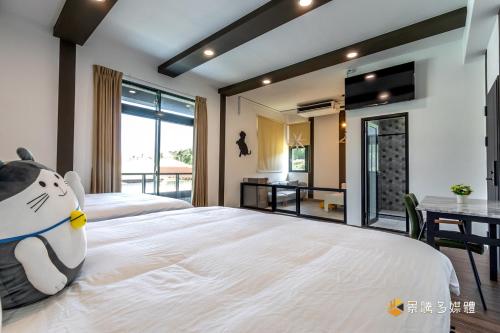 a bedroom with two beds and a dining room with a table at 快樂狗寵物民宿--證號2598 in Hualien City