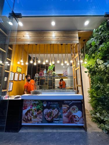 a fast food restaurant with two people standing in front of it at H Hotel El Nido - Vegan Friendly Hotel Managed by H Hospitality Group in El Nido