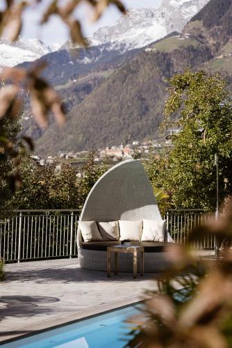 a couch sitting on a deck next to a pool at Residence Walchhof in Schenna