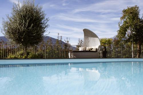 a swimming pool with a chair next to a fence at Residence Walchhof in Schenna