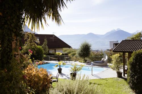 a backyard with a swimming pool with mountains in the background at Residence Walchhof in Schenna