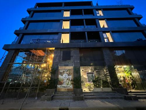 a tall building at night with lights on at H Hotel El Nido - Vegan Friendly Hotel Managed by H Hospitality Group in El Nido