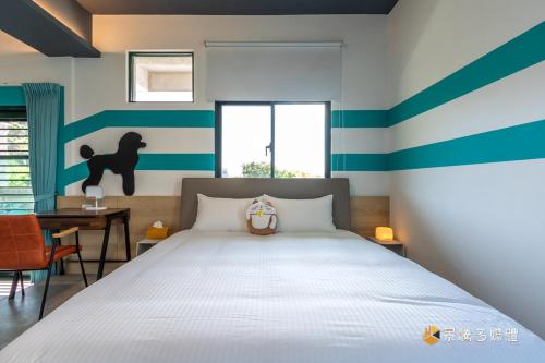 a bedroom with a bed with blue and white stripes at 快樂狗寵物民宿--證號2598 in Hualien City
