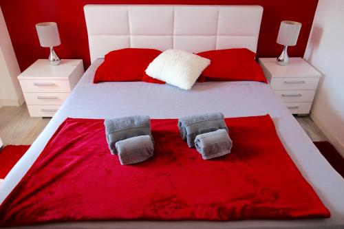una camera con un letto bianco con lenzuola rosse di Les chambres d'hôtes de L'Oliveraie a Opio
