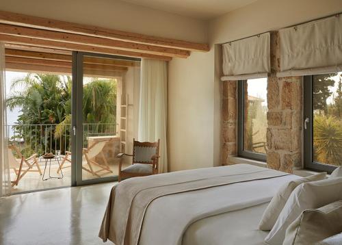 a bedroom with a large bed and large windows at F Zeen Kefalonia in Lourdata